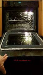 Holding the oven door open after its glass front has been broken away (C) Daniel Friedman at InspectApedia.com