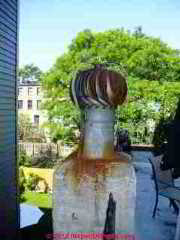 Rusty turbulator cap or turbine cap set atop a masonry chimney (C) Daniel Friedman