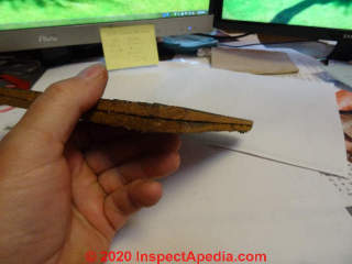 Brushed wood cedar shingle siding bonded to a fiberboard backer (C) InspectApedia.com SmallwoodK