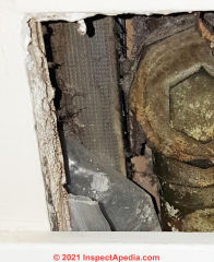 Fiberglass and other materials at a bathroom plumbing drain access (C) InspectApedia.com BPA