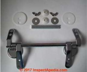 Wooden toilet seat hinge may accommodate various toilet seat hing bolt spacing distances (C) InspectApedia courtesy of Plumbers Mate U.K. - contact information given above 