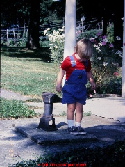Child standing on cover of a dug well - an attractive nuisance and a dangerous child hazard if the cover is not absolutely safe and secure (C) Daniel Friedman at InspectApedia.com
